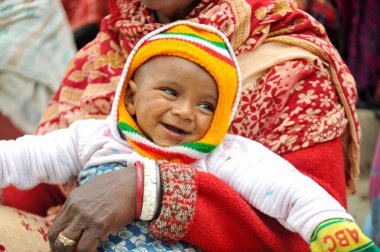 17 Ocak 2024 Sylhet-Bangladeş: Soğuk bir sabah Tarapur Çay Bahçesi 'nde gardiyanın kucağında bir çocuk. Sylhet 'te kış mevsiminin şiddetinin artması nedeniyle çocuklar ve yaşlılar acı çekiyor. 