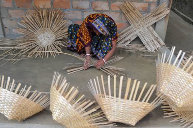 23 Ocak 2024, Sylhet, Bangladeş: Bir kadın, Sylhet, Bangladeş 'in dışındaki Nomshuddha Mahallesi' nde bambu kamışlarından yapılan ürünleri dokuyor.