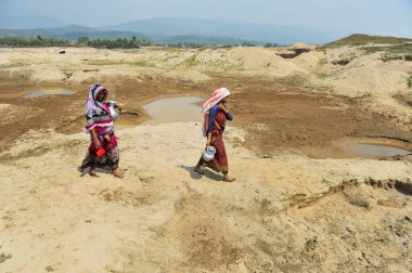 March 5, 2024, Sylhet, Bangladesh: Two housewives are collecting water for household use from an almost dry reservoir in Kalairag area of Bholaganj bordering Companiganj upazila clipart