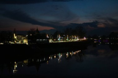 5 Mart 2024, Srinagar, Hindistan: Jhelum Nehri üzerinde akşam saatlerinde aydınlatılmış bir köprü görülür.