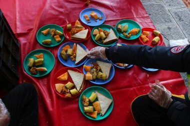 19 Mart 2024, Srinagar, Hindistan: Kaşmir Müslümanları kutsal Ramazan ayında bir caminin önünde, insanlar için yemek hazırlıyorlar.