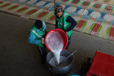 19 Mart 2024, Srinagar, Hindistan: Kaşmir Müslümanları kutsal Ramazan ayında bir caminin önünde, insanlar için yemek hazırlıyorlar.