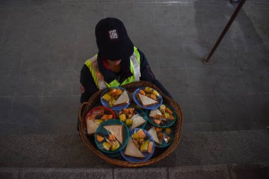 19 Mart 2024, Srinagar, Hindistan: Bir adam kutsal Ramazan ayında bir caminin önünde içi dolu yiyecek dolu bir sepet taşıyor