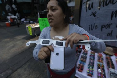 9 Nisan 2024, Mexico City, Mexico City: Bağımsızlık Meleği 'nin çevresinde toplanan insanlar, güneşin kısmi tutulmasını gözlemlemek için özel lensler kullandılar.