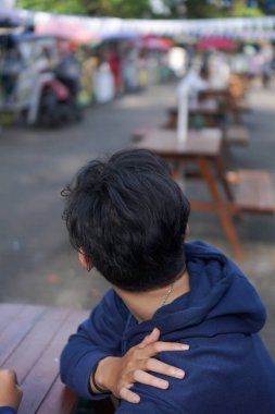 Parkta yalnız takılan genç bir adamın fotoğrafı. Model, tasarım ögesi vs. için uygun.