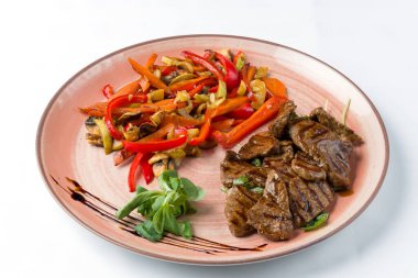 Beyaz arka planda ızgara biftek şeritleri, jülyen havuçları, kapsika, mantar ve baharatlar..