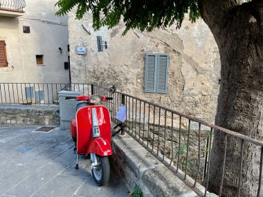 Klasik bir İtalyan scooter 'ı, İtalya' nın Sarteano şehrinin arka planına karşı. Yüksek kaliteli fotoğraf.