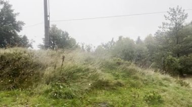 Arka planda yağmur, Çek Dağları 'nda sağanak yağmur, yağmur damlaları, mevsim arkaplanı. Elektrik hatları. Yüksek kaliteli FullHD görüntüler