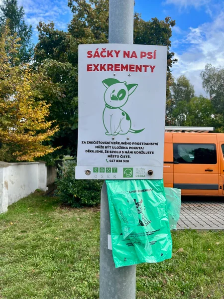 OSEK, CZECH REPUBLIC - 14.10.2023: Pet waste station. Green bag for dog feces. . High quality photo