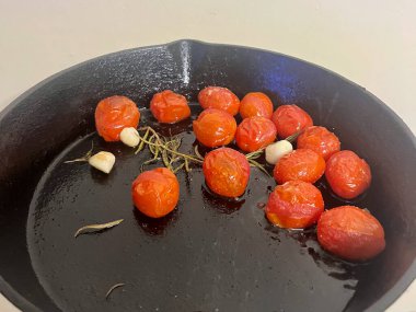 Dökme demir tavada, sarımsaklı vişneli domates kızartması. - Evet. Yüksek kalite fotoğraf
