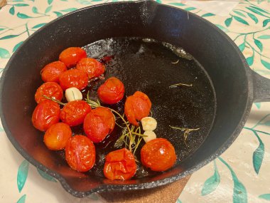 Dökme demir tavada, sarımsaklı vişneli domates kızartması. - Evet. Yüksek kalite fotoğraf