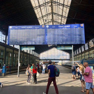 Budapeşte, Macaristan - 03.08.2019: İnsanlar tren istasyonundaki tren çizelgesine bakıyorlar. Yüksek kalite fotoğraf