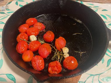 Dökme demir tavada, sarımsaklı vişneli domates kızartması. - Evet. Yüksek kalite fotoğraf