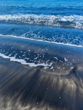 Sahilde küçük okyanus dalgaları. Tenerife. Kanarya Adası. İnanılmaz bir gökyüzü. Yüksek kalite fotoğraf