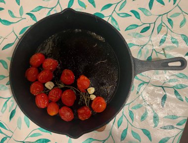 Dökme demir tavada, sarımsaklı vişneli domates kızartması. - Evet. Yüksek kalite fotoğraf