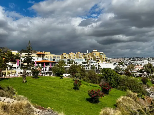 Beach of Fanabe, Costa Adeje, waves, Atlantic ocean. White-grey menacing clouds over the city. Islands of eternal spring. A popular tourist destination in Europe. High quality photo