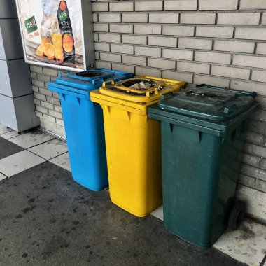 Belgrad, Sırbistan - 03.08.2019: Ayrı atık toplama işlemleri için çok renkli plastik kutular. Çevre dostu çöp toplama, ama otobüs durağında çok kirli çöp bidonları. 