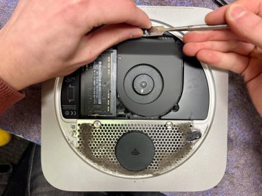 Yakın plan erkek elleri bakım ve profilaksi sırasında bilgisayarın soğutma sistemini temizler. Elektronik cihaz konseptinin tamiri. İçeride. Yüksek kalite fotoğraf