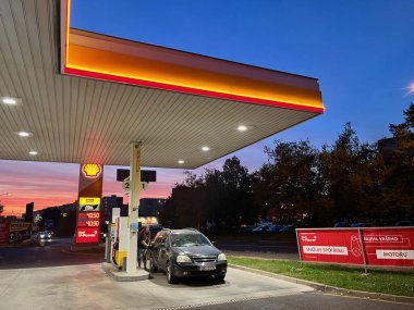 Teplice, Çek Cumhuriyeti - 02.10.2023: Bir benzin istasyonu ve hoş bir mor gün batımı. Yüksek kalite fotoğraf