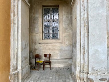 Two lonely chairs standing in an archway. Duchcov city, Czech Republic. High quality photo clipart