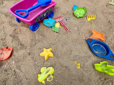 Oyuncaklar büyük bir çocuk kum havuzuna saçılmıştır. Çocukluk ve çocukların rahatlığı. Renkli plastik oyuncaklar. Yüksek kalite fotoğraf