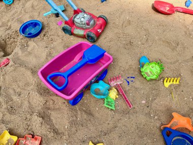 Oyuncaklar büyük bir çocuk kum havuzuna saçılmıştır. Çocukluk ve çocukların rahatlığı. Renkli plastik oyuncaklar. Yüksek kalite fotoğraf
