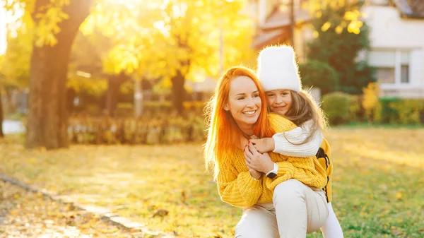 秋の散歩で遊んでいる母親と子供の娘 ママと女の子は屋外で笑っている 秋のファッション 秋の公園で幸せな家族 — ストック写真