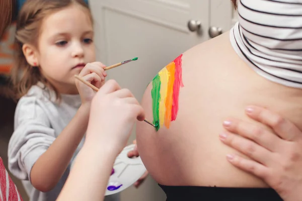 Happy Little Girl Drawing Rainbow Pregnant Belly Her Mother Baby – stockfoto