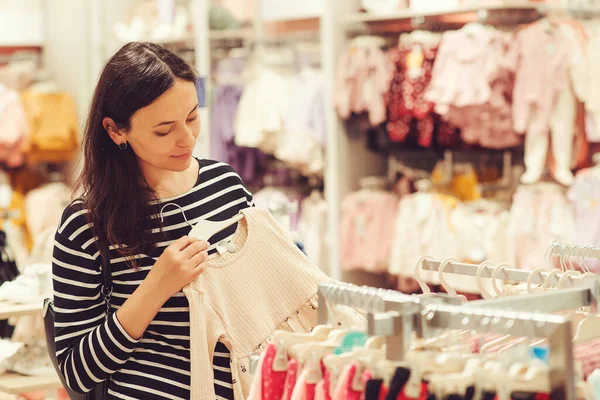 妈妈在婴儿商店里购物 婴儿时尚 购物时间 销售和怀孕的概念 怀孕妇女为她未来的女儿选择衣服 — 图库照片
