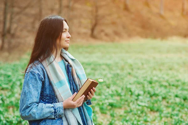 自然の中で春の日を楽しむ女性 ライフスタイル 人々と春の時間 散歩中の本を持つ若い女性 読書の時間だ 読書の概念 — ストック写真