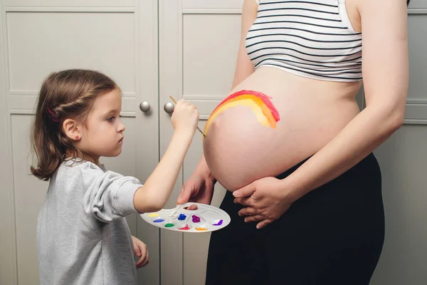 Happy Little Girl Drawing Rainbow Pregnant Belly Her Mother Baby — Stock fotografie