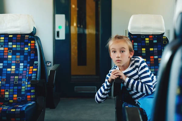 可爱的男孩坐在通勤的电动火车上 小孩在火车上旅行 家庭假期 生活方式 — 图库照片
