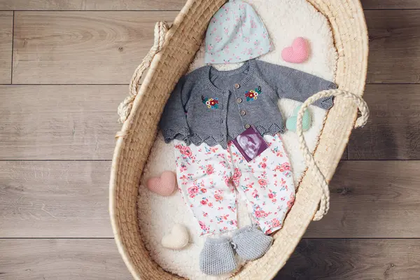 Korb Mit Babykleidung Weidenkorb Mit Babysachen Und Zubehör Für Neugeborene lizenzfreie Stockbilder