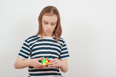 Uzghorod, Ukrayna - Nisan 04, 2023: Rubik küpüyle oynayan genç çocuk. Rubik küpü çocuğun ellerinde..
