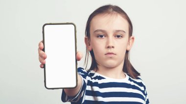 Elinde beyaz bir ekranla cep telefonu tutan genç bir çocuk. Model için boş alanı olan Gadget. Gülümseyen öğrenci..