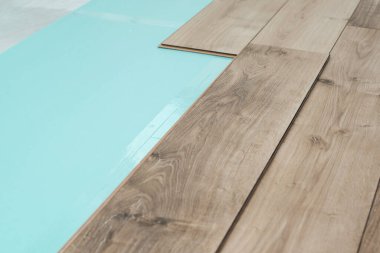 Döşeme ve iç dizayn için ahşap dokuyla kaplanmış. Kaplama döşeme kuruluyor. Kaplamalı zemin döşeniyor. Ahşap fayanslar hazır. Arkaplanı yumuşat.