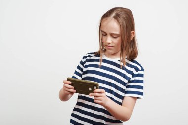 Heyecanlı çocuk cep telefonuyla oyun oynuyor. Cep telefonuyla gezen bir öğrenci. Aleti olan mutlu bir çocuk. Yaşam tarzı, eğitim kavramı.