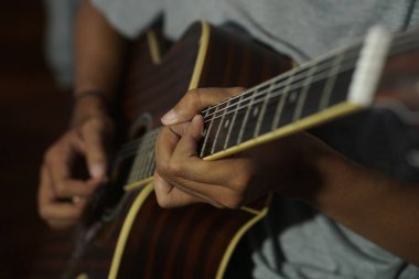 Yakın plan akustik gitar çalan adam.