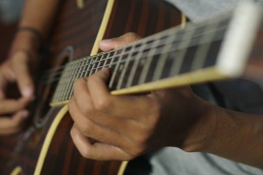 Yakın plan akustik gitar çalan adam.