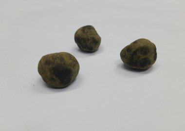 Beyaz arka planda bir yığın taze siyah beyaz hap.