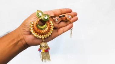 Beyaz arka planda bilezikleri olan bir kadın eli.