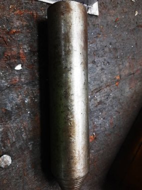 Arka planda eski metal boru ve boru var.