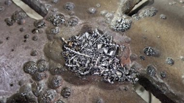 Duvarın arka planında paslı metal bir boru var.