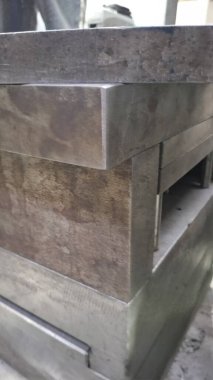 Eski ahşap duvarın arka planında beyaz saplı metal plaka.