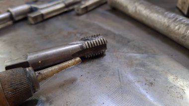 Eski makine metali bir aletle kesiyor..