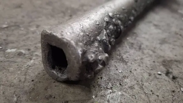 Çekiçli eski metal boru.