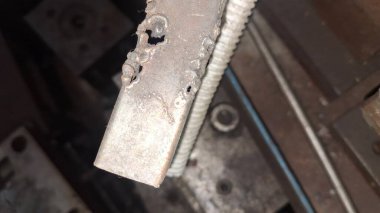 Evin arka planında paslı metal bir zincir var.