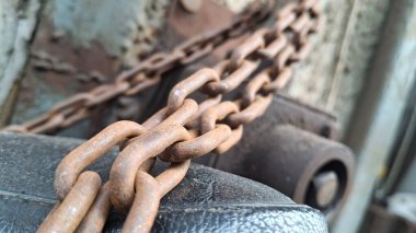Çitin arka planında paslı metal zincir.