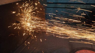 Karanlıkta metal öğütücüye ve çelik boruya yakın dur. Çelik kıvılcımlar.