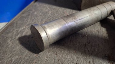 Ahşap zeminin arkasında metal bir boru var.